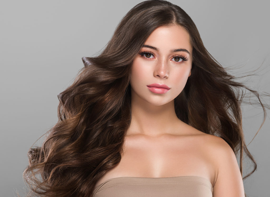 Beautiful brunette long curly hair woman with beauty makeup and